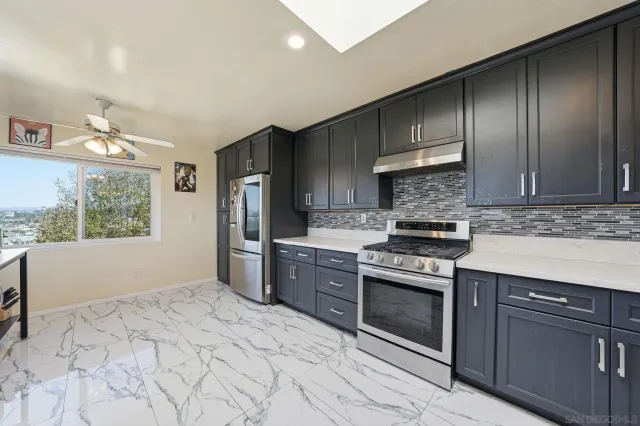 a kitchen with stainless steel appliances kitchen island granite countertop a sink counter top space and cabinets