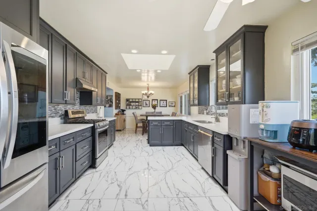 a kitchen with stainless steel appliances a refrigerator sink and microwave