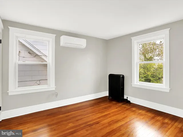 an empty room with wooden floor and a window