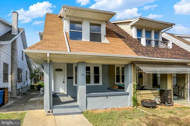 a view of a brick house with large windows and plants
