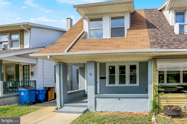 a view of a white house with many windows and plants