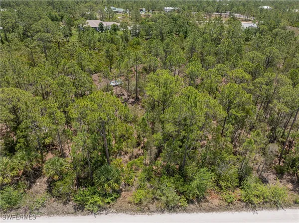 an aerial view of residential house with outdoor space and trees all around