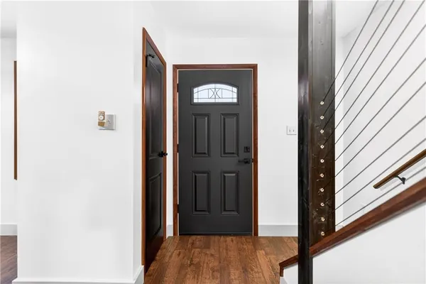 a view of a hallway with wooden floor and staircase