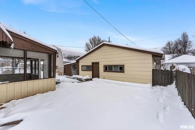 a front view of house with yard and trees in the background