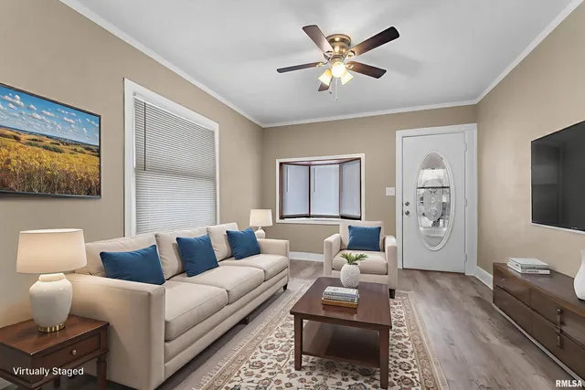 a living room with furniture a ceiling fan a rug and a window