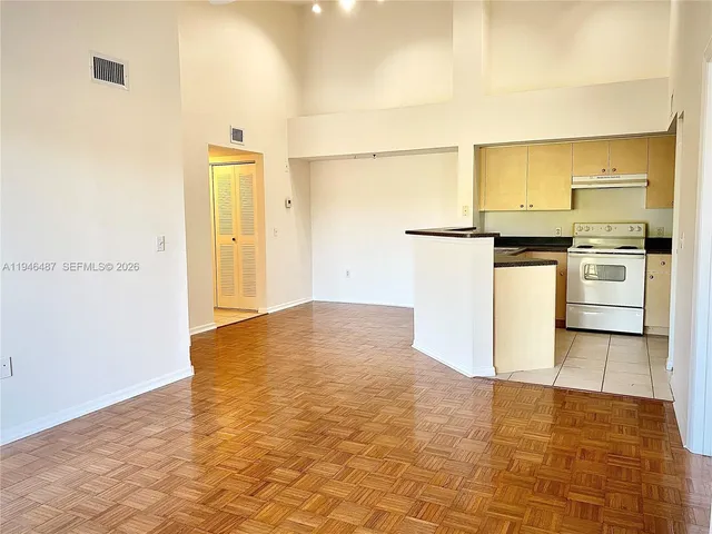 a kitchen with granite countertop a refrigerator and a stove top oven