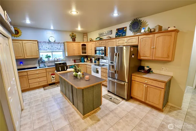 a kitchen with stainless steel appliances granite countertop a sink a stove and a refrigerator