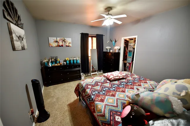 a bedroom with a bed dresser and a large mirror