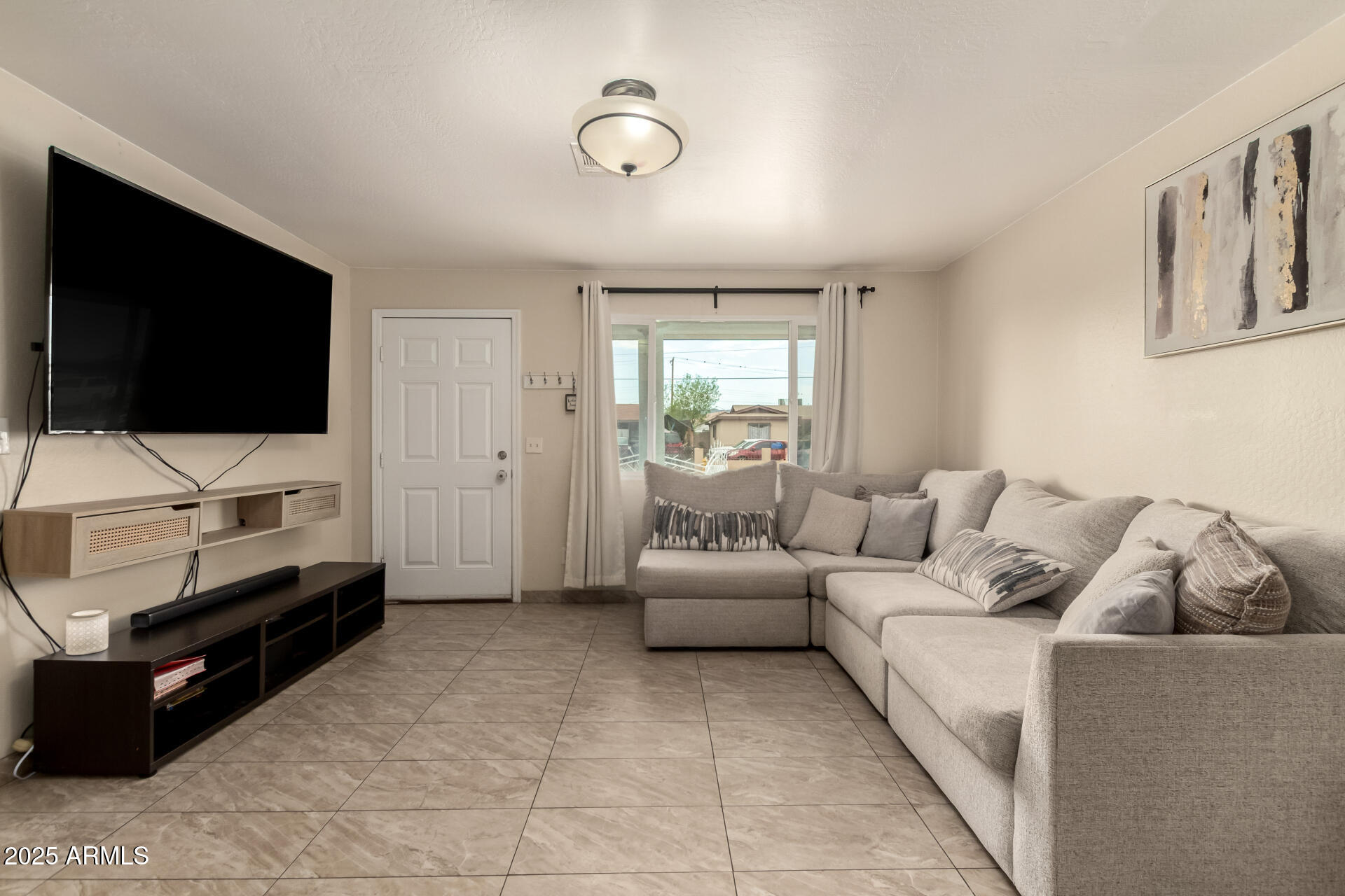 2024 West Roeser Road Phoenix, AZ 85041 - Photo 11 of 36 a living room with furniture and a flat screen tv