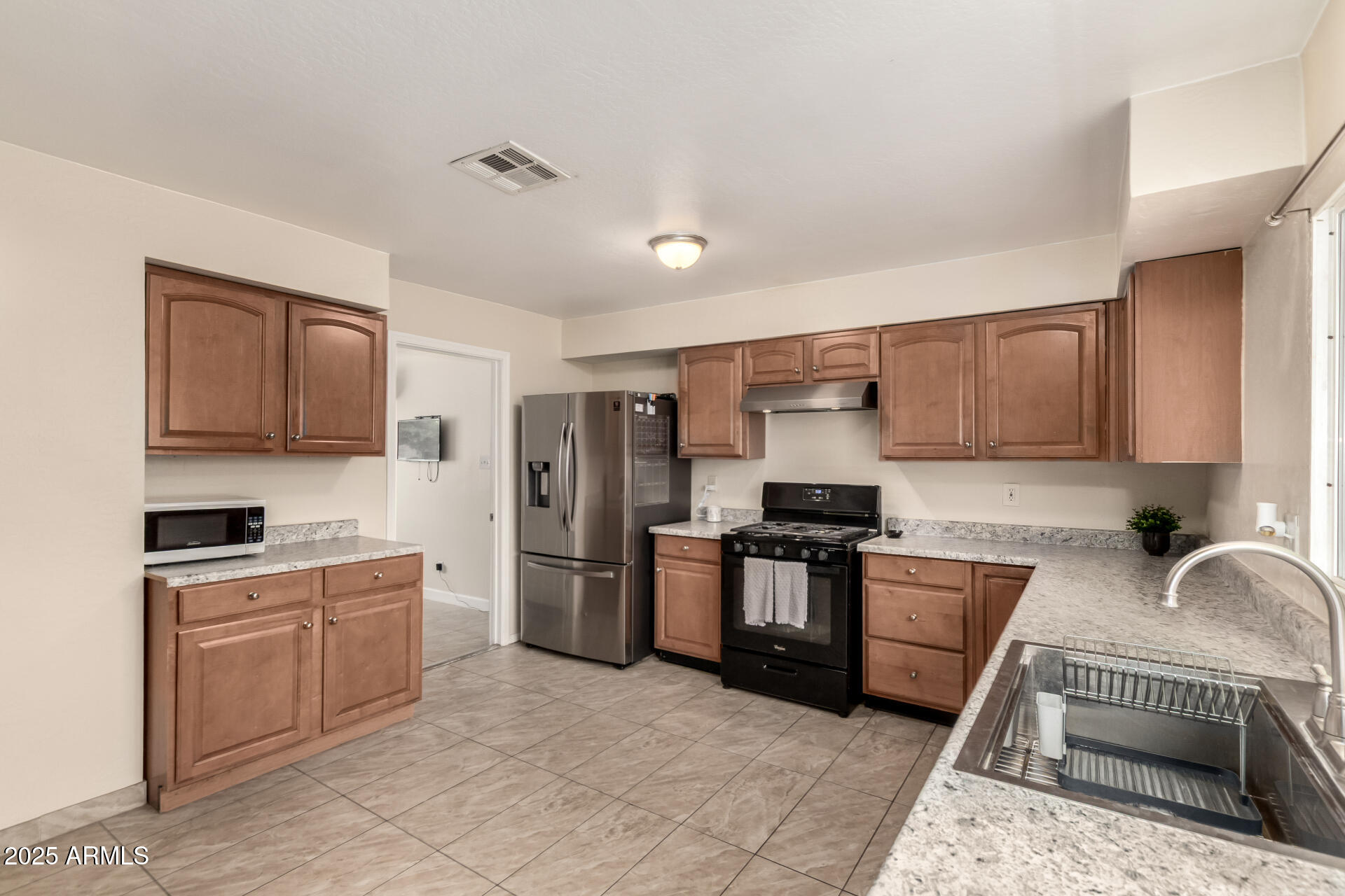 2024 West Roeser Road Phoenix, AZ 85041 - Photo 15 of 36 a kitchen with stainless steel appliances granite countertop a stove top oven a sink dishwasher and a refrigerator
