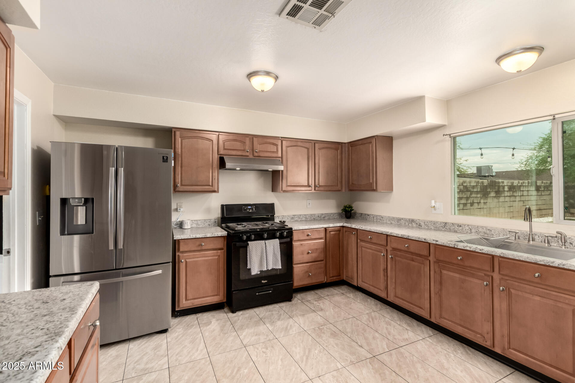 2024 West Roeser Road Phoenix, AZ 85041 - Photo 18 of 36 a kitchen with stainless steel appliances granite countertop a sink stove and refrigerator