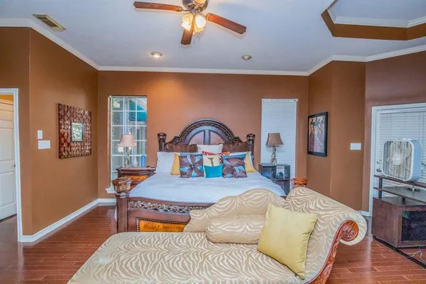 a bedroom with a bed and a flat tv screen on dresser