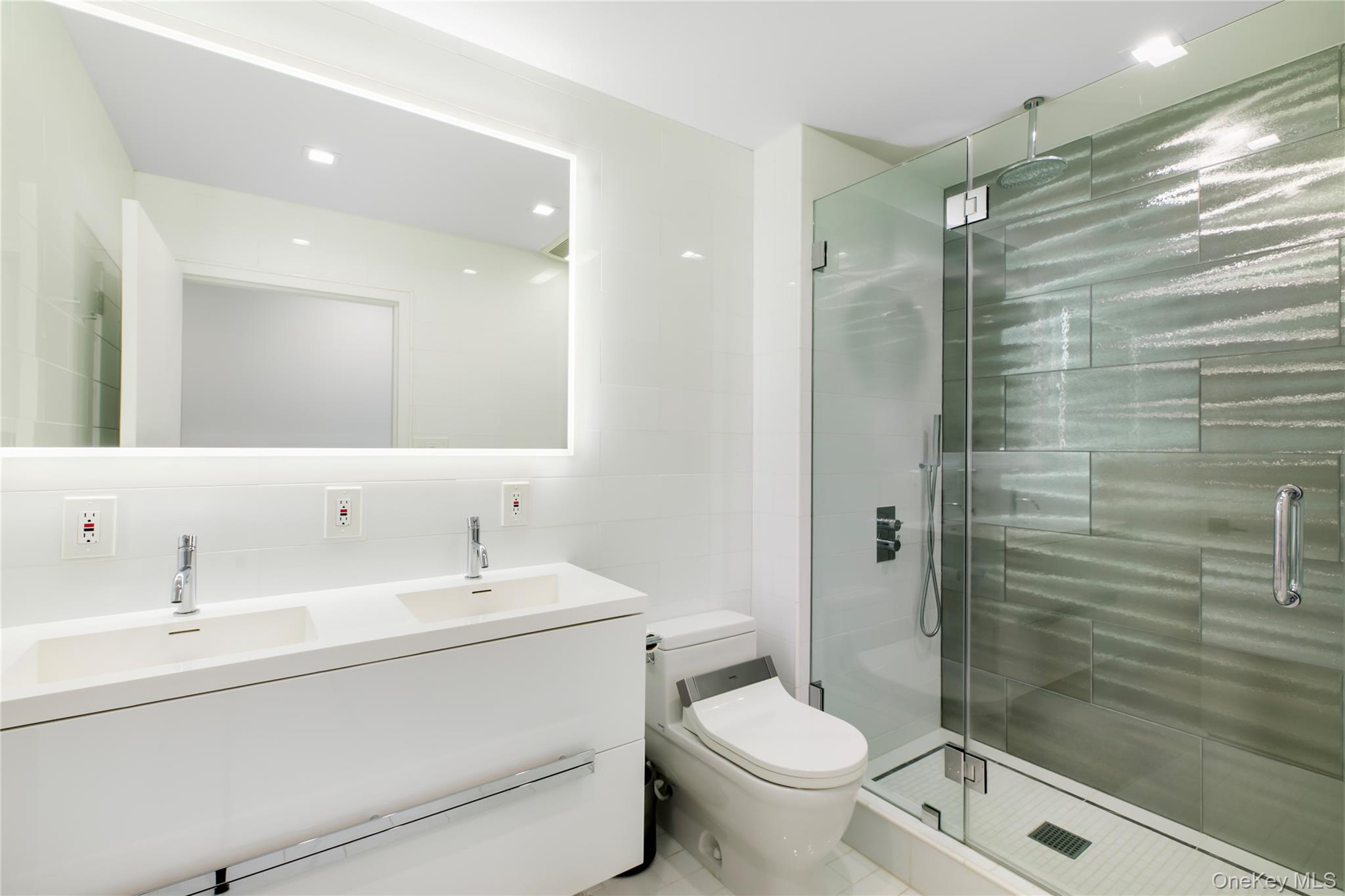 260 Dune Road, Unit 101G Westhampton Beach, NY 11978 - Photo 13 of 16 a bathroom with a double vanity sink toilet and shower