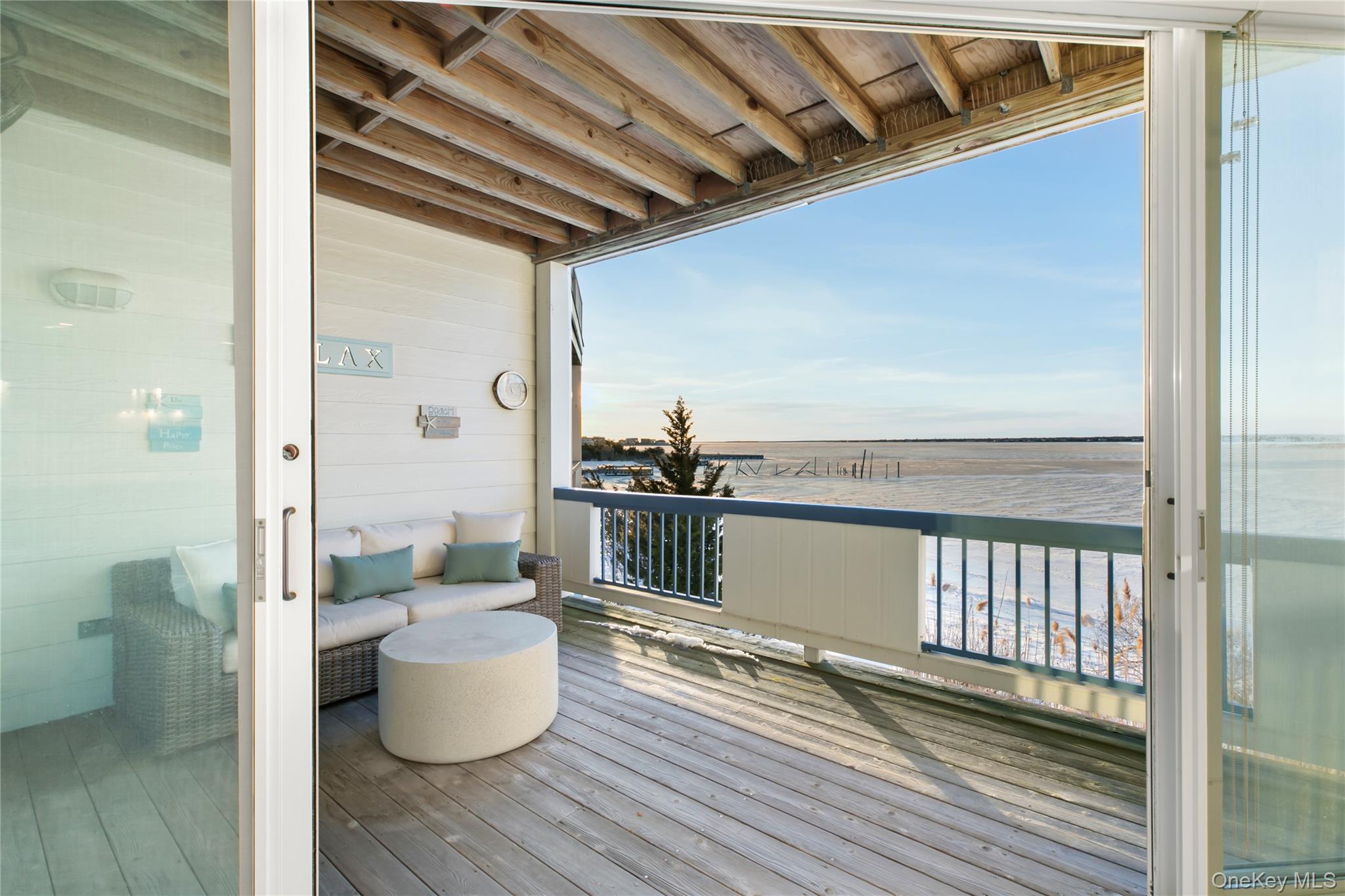 260 Dune Road, Unit 101G Westhampton Beach, NY 11978 - Photo 7 of 16 a view of a balcony with chair and wooden floor