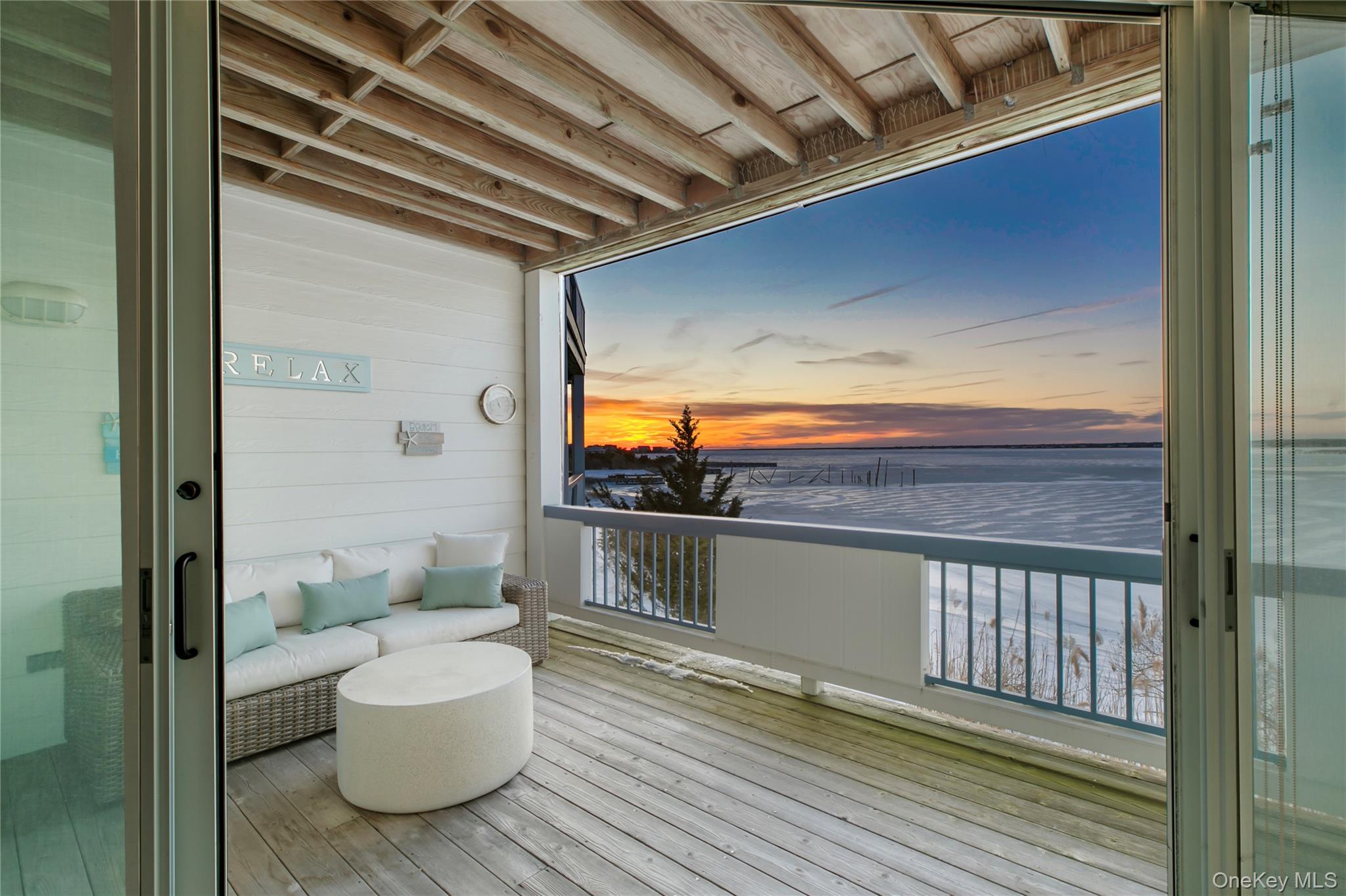 260 Dune Road, Unit 101G Westhampton Beach, NY 11978 - Photo 8 of 16 a view of a balcony with chair and glass door