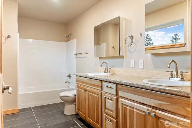 a bathroom with a double vanity sink toilet and shower