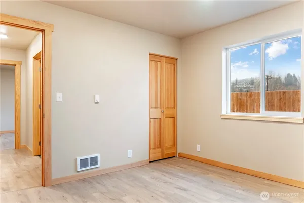 an empty room with windows and closet