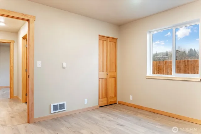an empty room with windows and closet