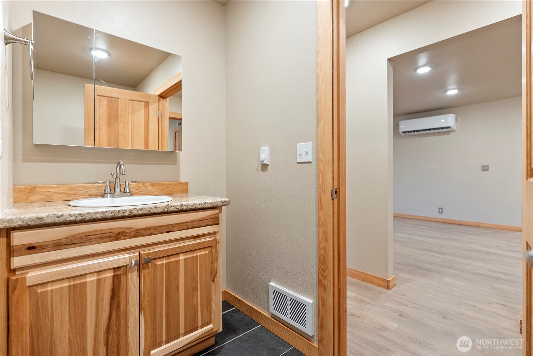 1110 Riverside Avenue Twisp, WA 98856 - Photo 21 of 28 a bathroom with a granite countertop sink a mirror and a shower