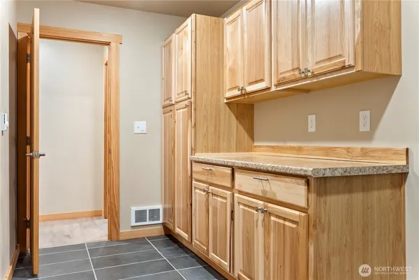 a view of a kitchen with white cabinets and a window