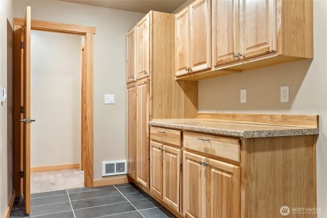 a view of a kitchen with white cabinets and a window