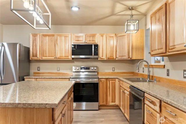 a kitchen with stainless steel appliances granite countertop a sink stove and refrigerator
