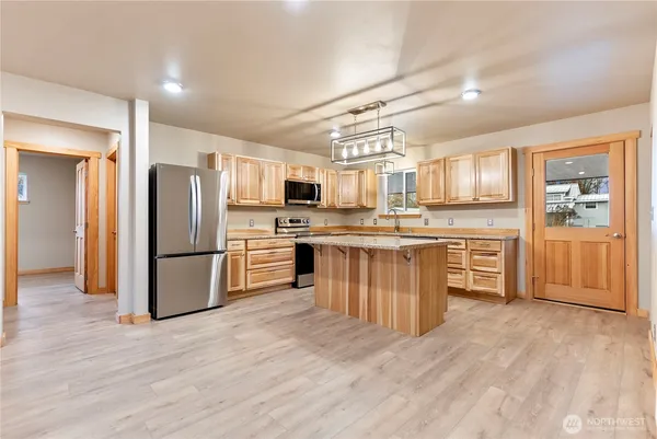 a kitchen with stainless steel appliances a refrigerator and wooden cabinets