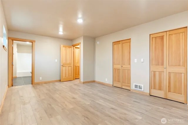 a view of empty room with wooden floor and entryway