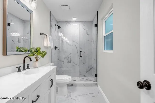 a bathroom with a toilet sink and shower