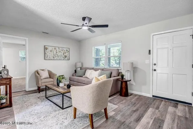 a living room with furniture and a wooden floor