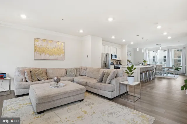 a living room with furniture and a dining table with kitchen view