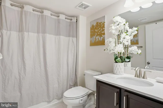 a bathroom with a sink vanity mirror and toilet