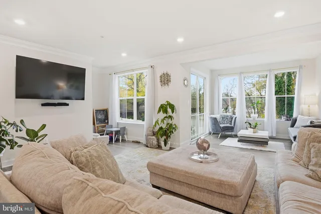 a living room with furniture flat screen tv and a large window
