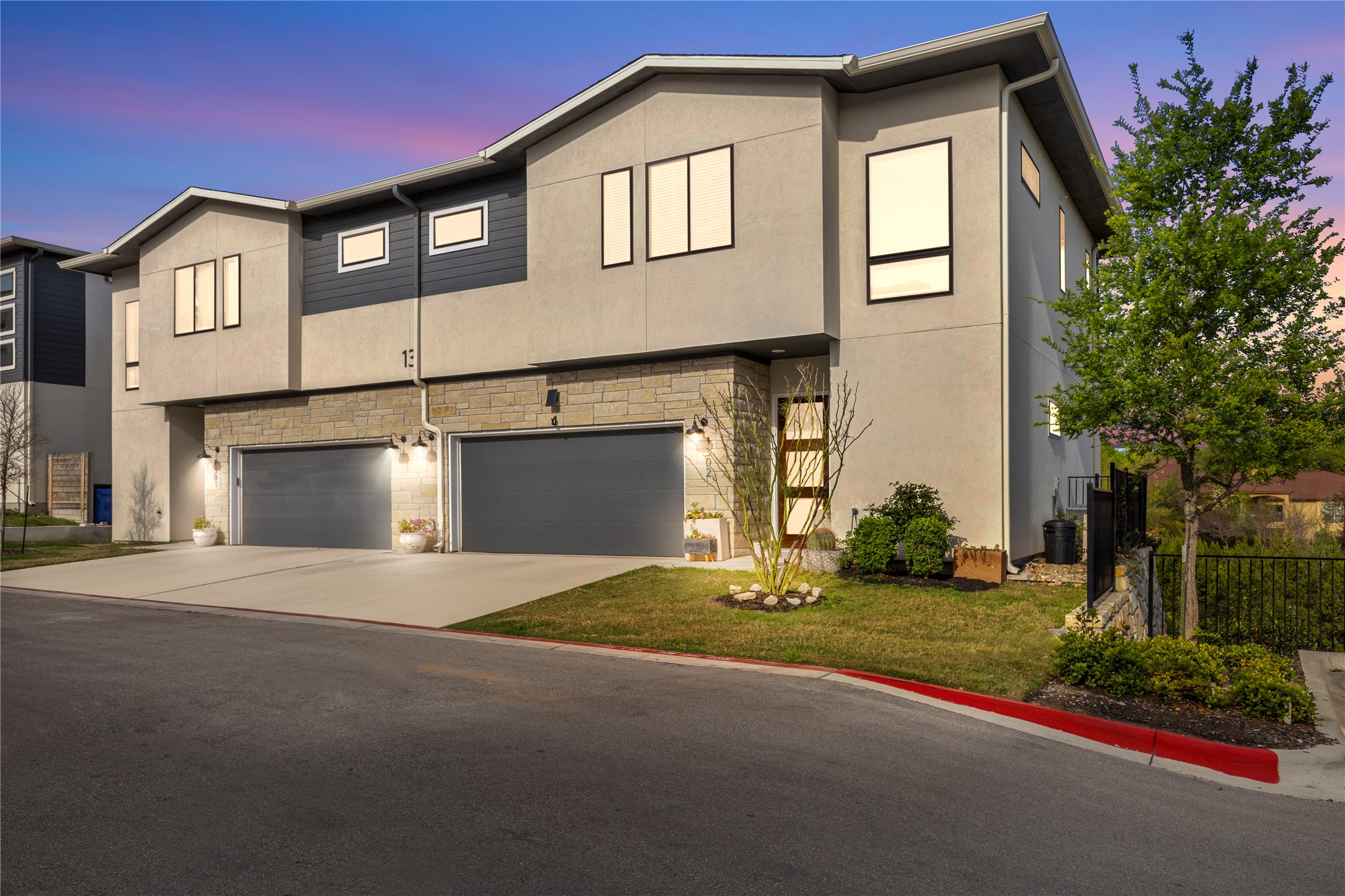 2050 Lohmans Spur Road, Unit 1302 Lakeway, TX 78734 - Photo 2 of 18 a front view of a house with a yard and garage
