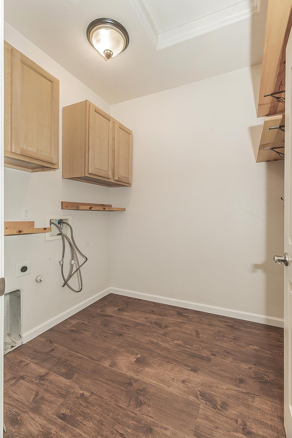 7357 East Redlands Avenue Fresno, CA 93737 - Photo 21 of 59 Indoor laundry bathroom with electric dryer hookup and storage cabinets and shelvings.