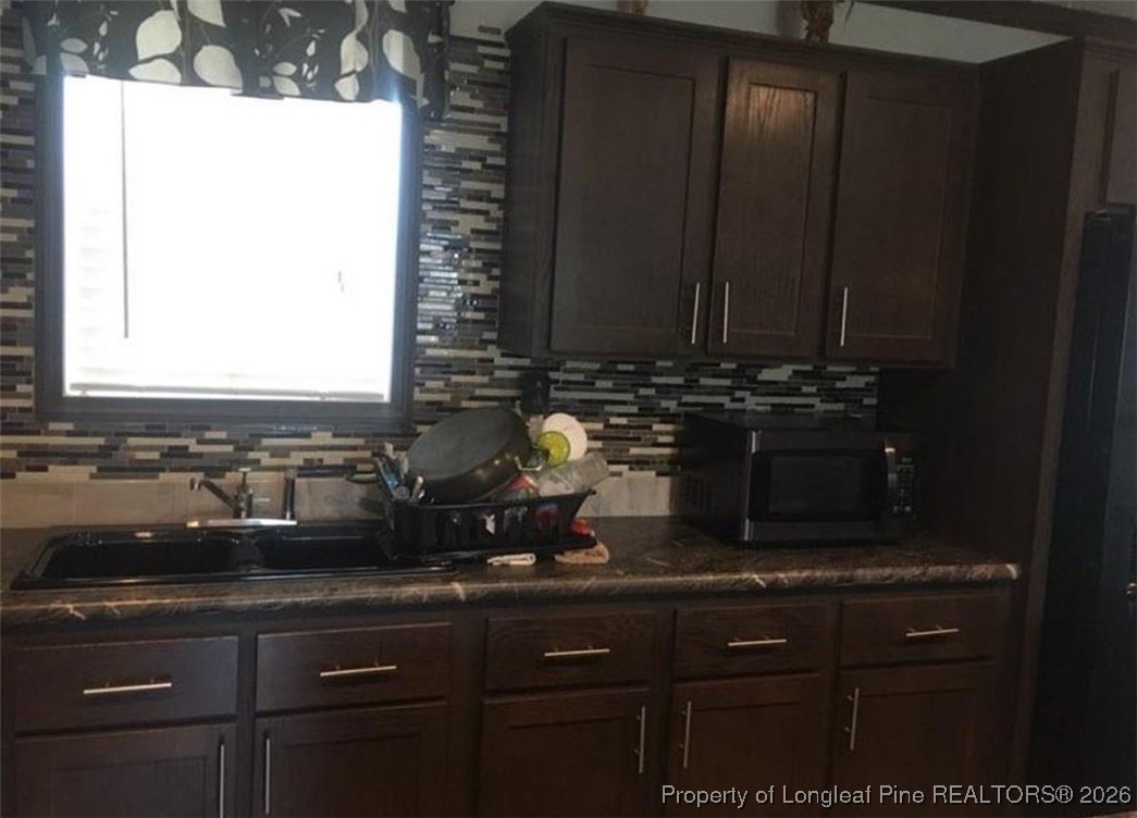 2754 Snipes Road Red Springs, NC 28377 - Photo 9 of 25 a sink with granite countertop cabinets and a sink