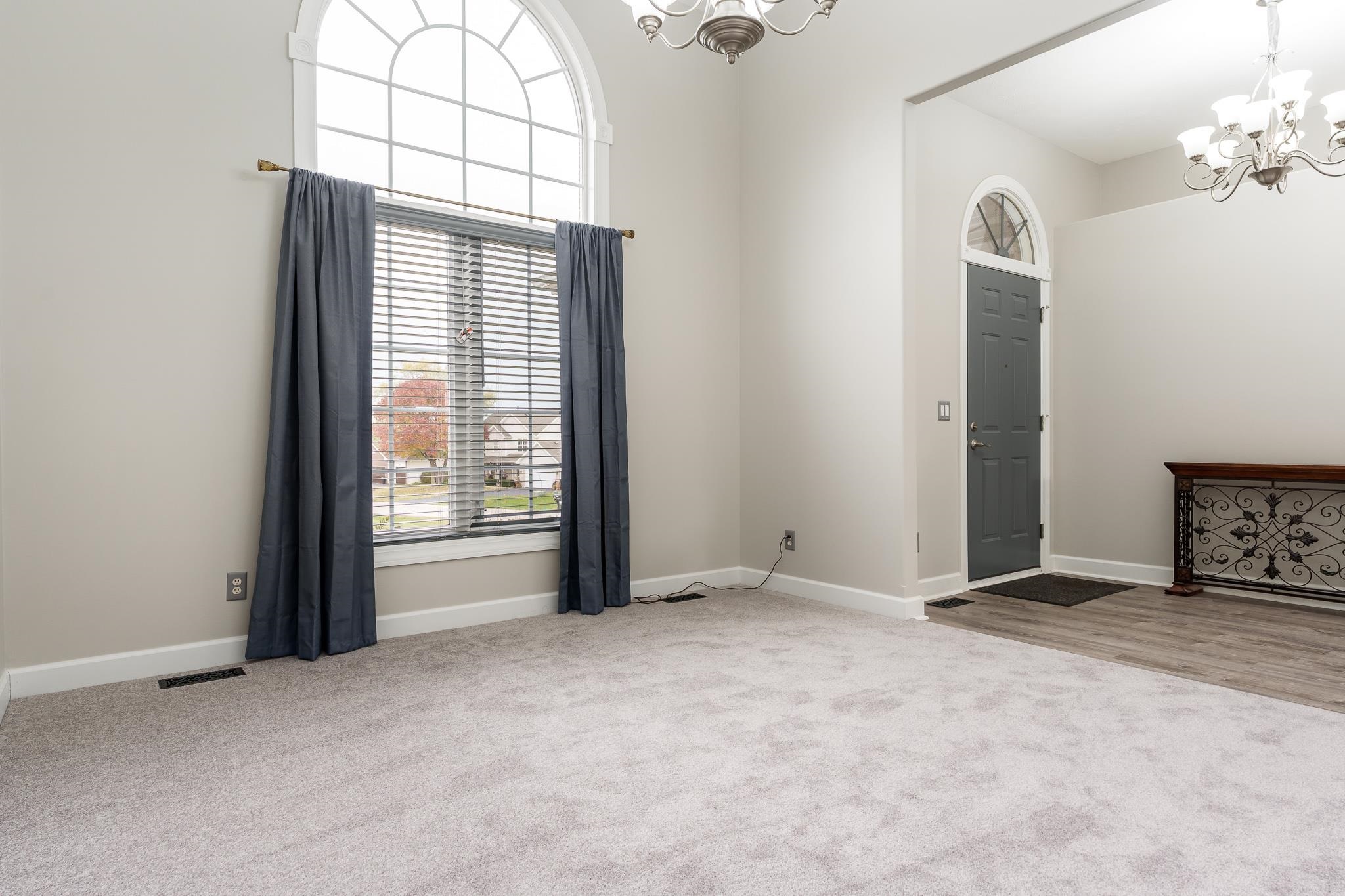 664 Elberon Way Roscoe, IL 61073 - Photo 13 of 63 an empty room with windows and a chandelier