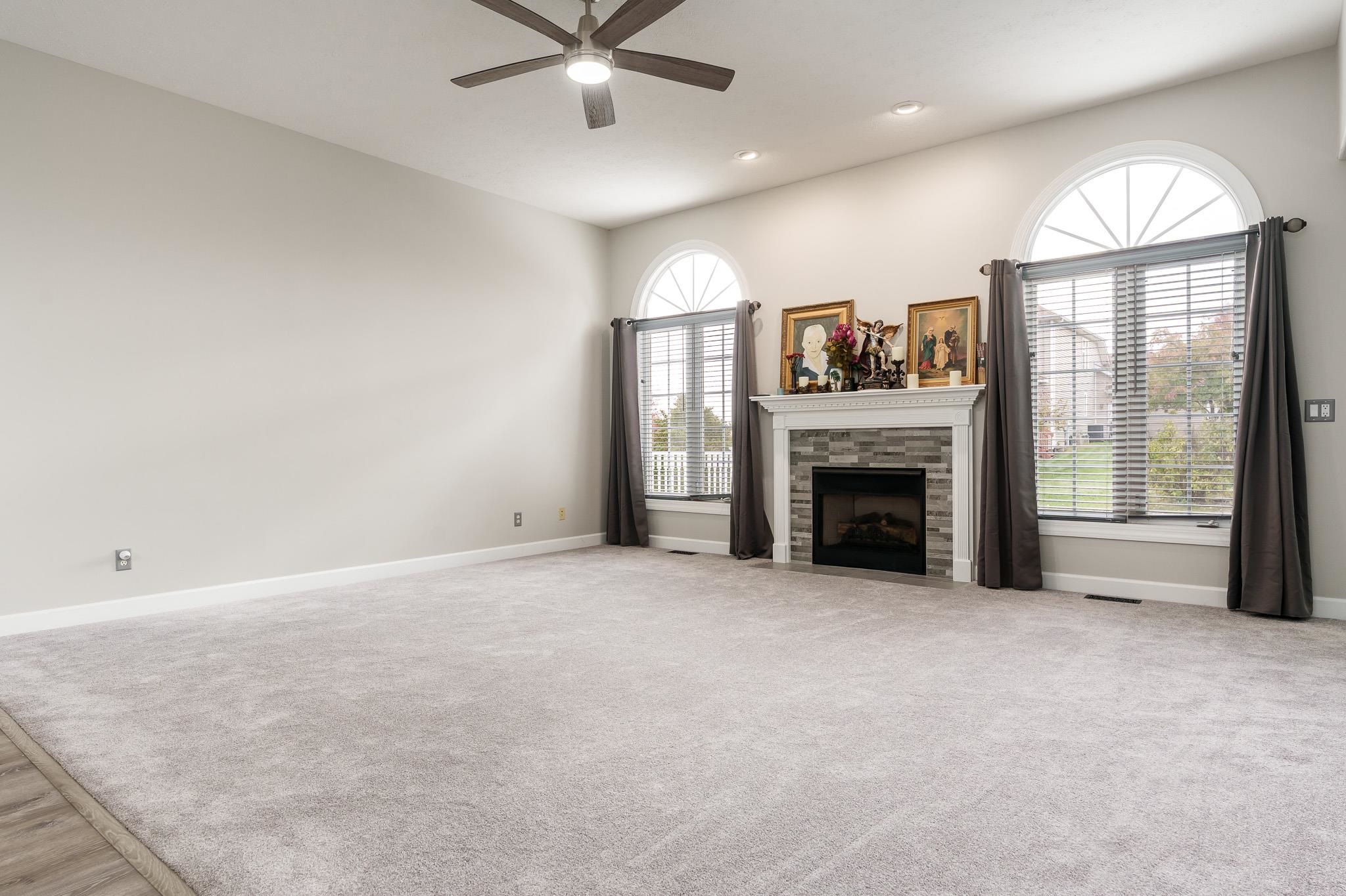 664 Elberon Way Roscoe, IL 61073 - Photo 15 of 63 an empty room with fireplace fan and windows