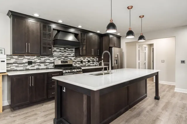 a kitchen with lots of counter space a sink appliances and dining table