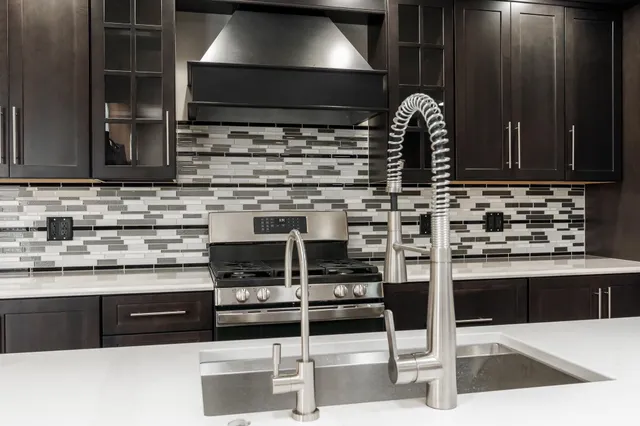 a kitchen with kitchen island a sink and a stove with wooden floor