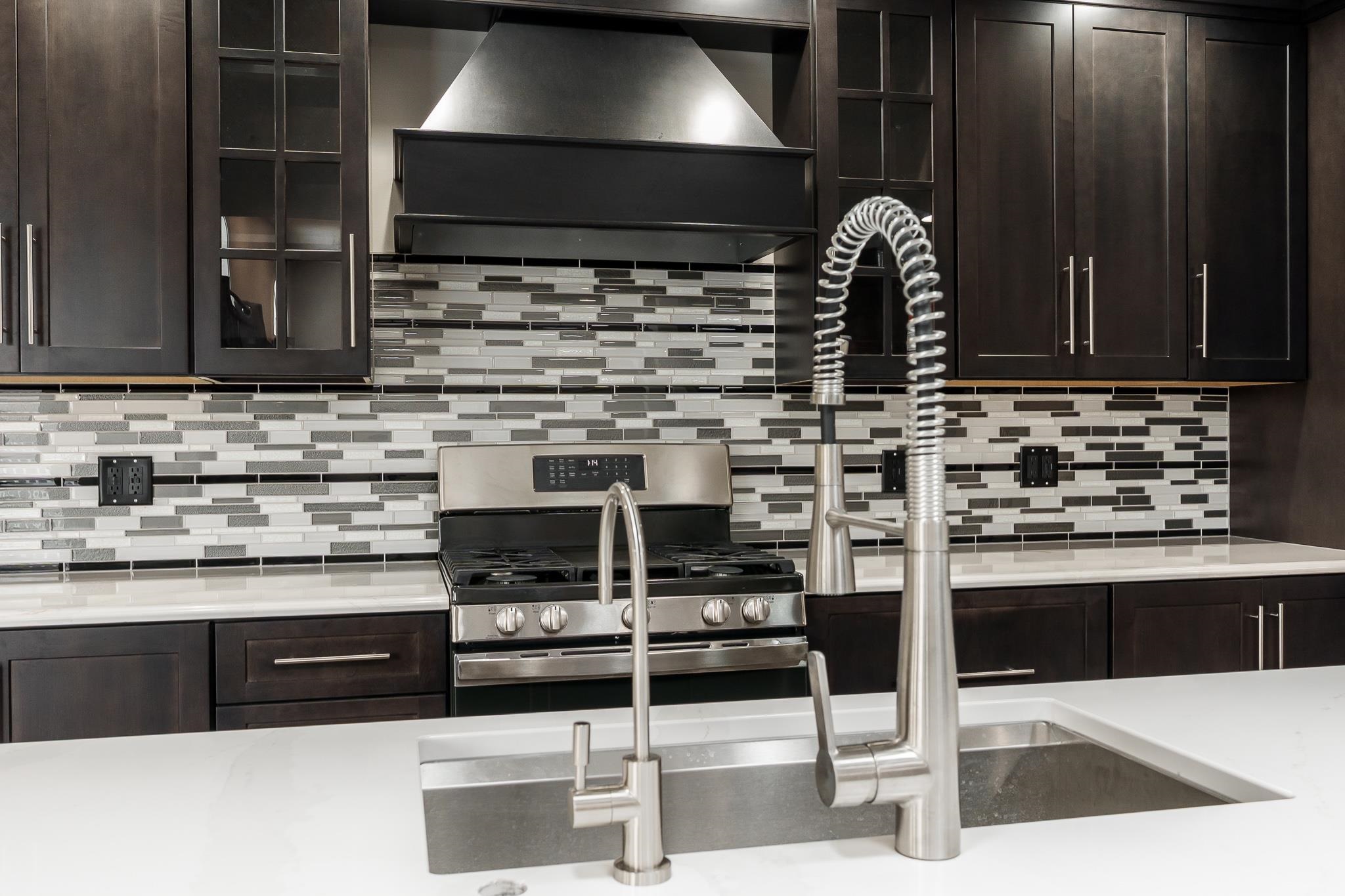 664 Elberon Way Roscoe, IL 61073 - Photo 20 of 63 a kitchen with stainless steel appliances kitchen island granite countertop a stove and a sink