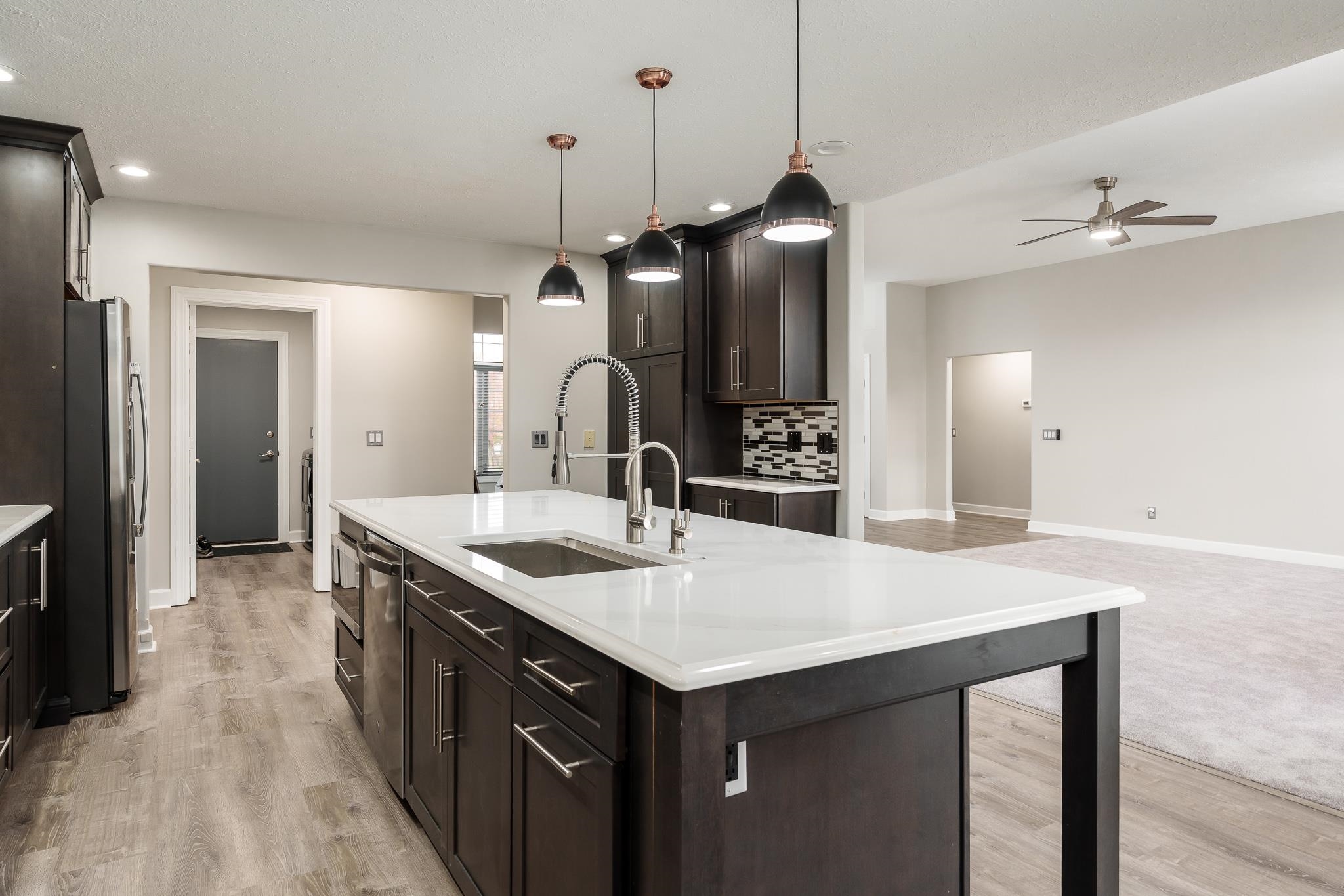664 Elberon Way Roscoe, IL 61073 - Photo 21 of 63 a kitchen with a sink a center island a stove and a wooden floor