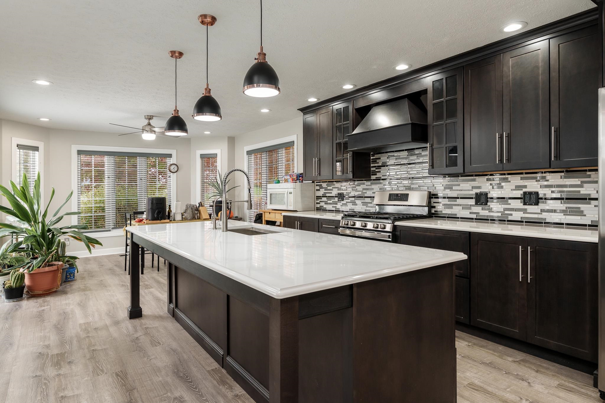 664 Elberon Way Roscoe, IL 61073 - Photo 23 of 63 a kitchen with kitchen island a sink and a stove with wooden floor