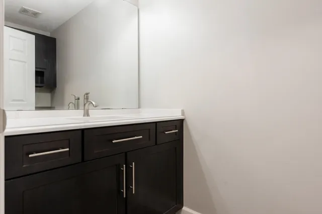 a bathroom with a double vanity sink a mirror and a shower