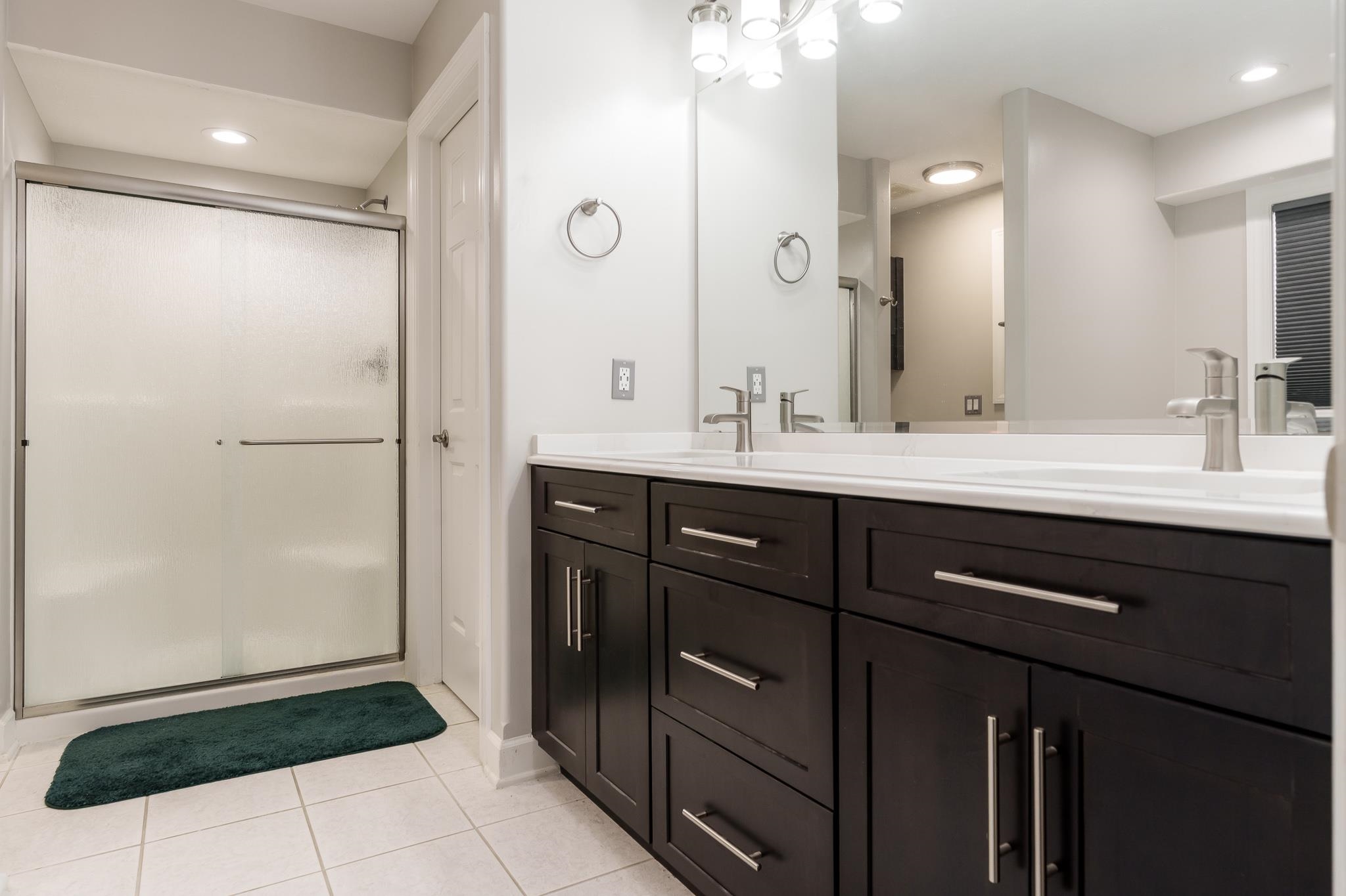 664 Elberon Way Roscoe, IL 61073 - Photo 29 of 63 a bathroom with a double vanity sink a mirror and a shower