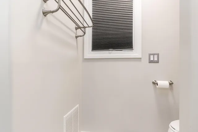 a white toilet sitting next to a window