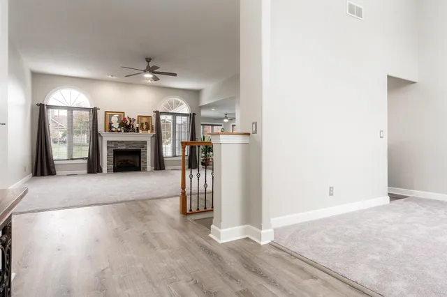 an empty room with windows and a chandelier