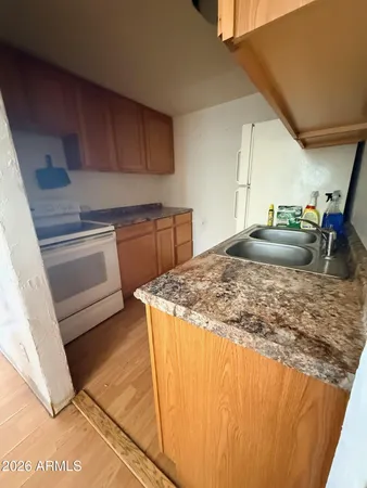 a kitchen with kitchen island granite countertop a sink stove and cabinets