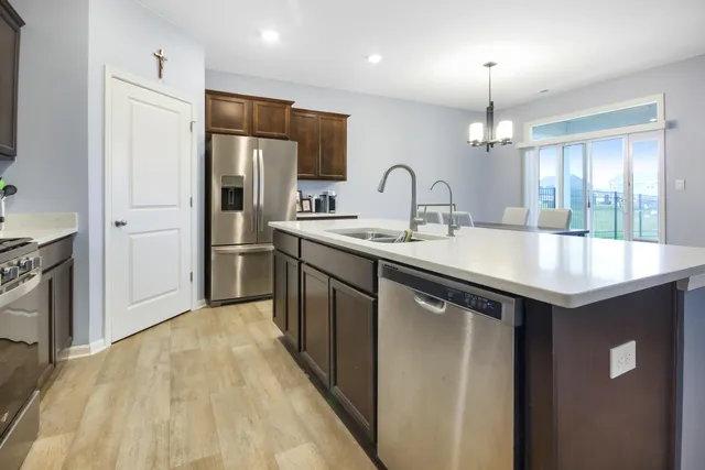 a kitchen with stainless steel appliances granite countertop a sink a stove and refrigerator