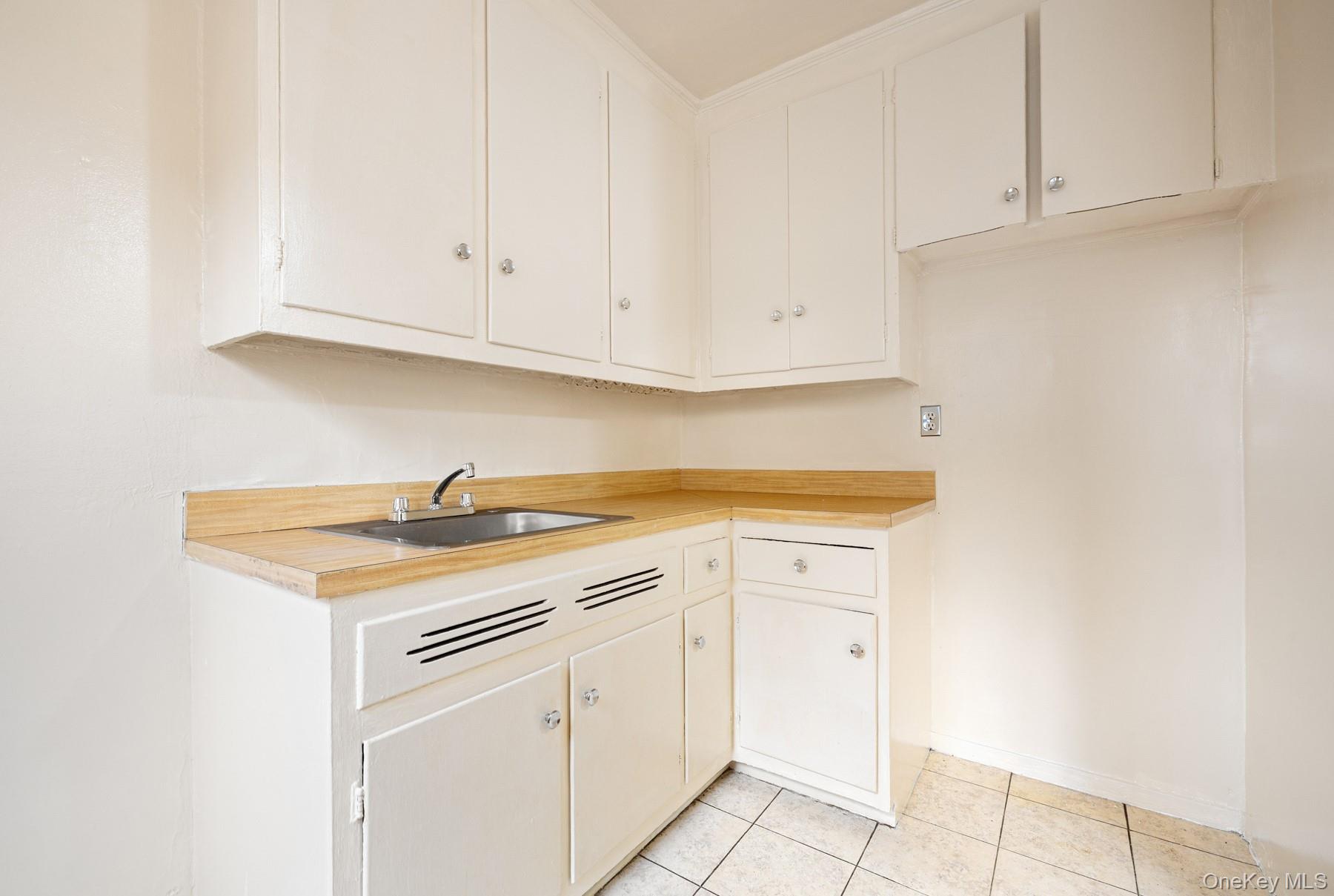 3130 Grand Concourse, Unit 2J Bronx, NY 10458 - Photo 11 of 27 a kitchen with granite countertop white cabinets and white appliances